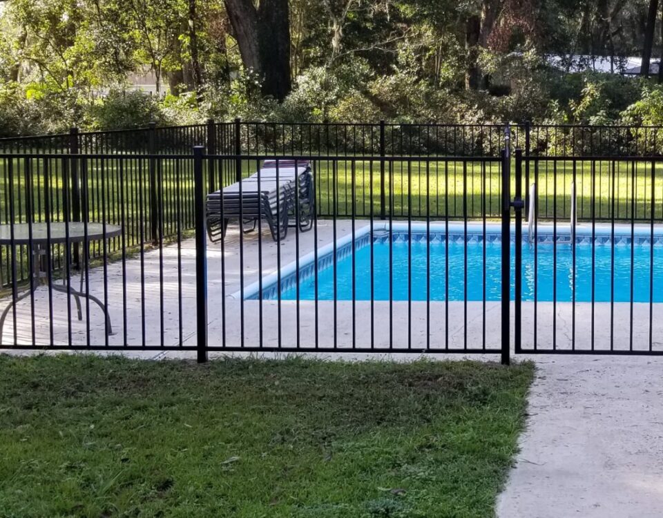 Black aluminum fence installed with masonry columns on a residential property
