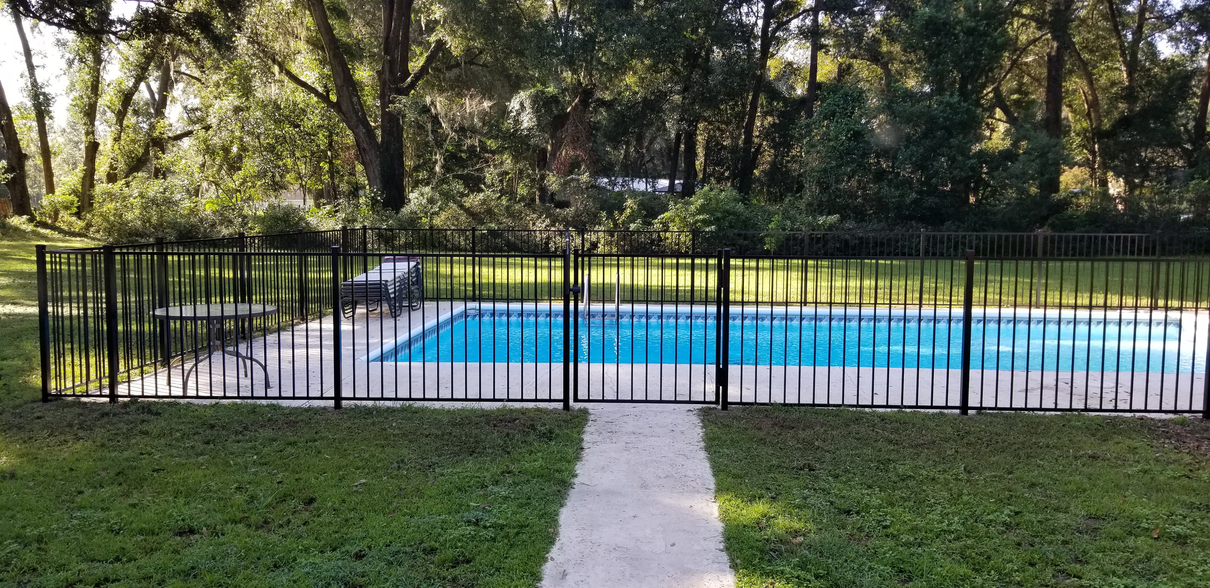 Black aluminum fence installed with masonry columns on a residential property