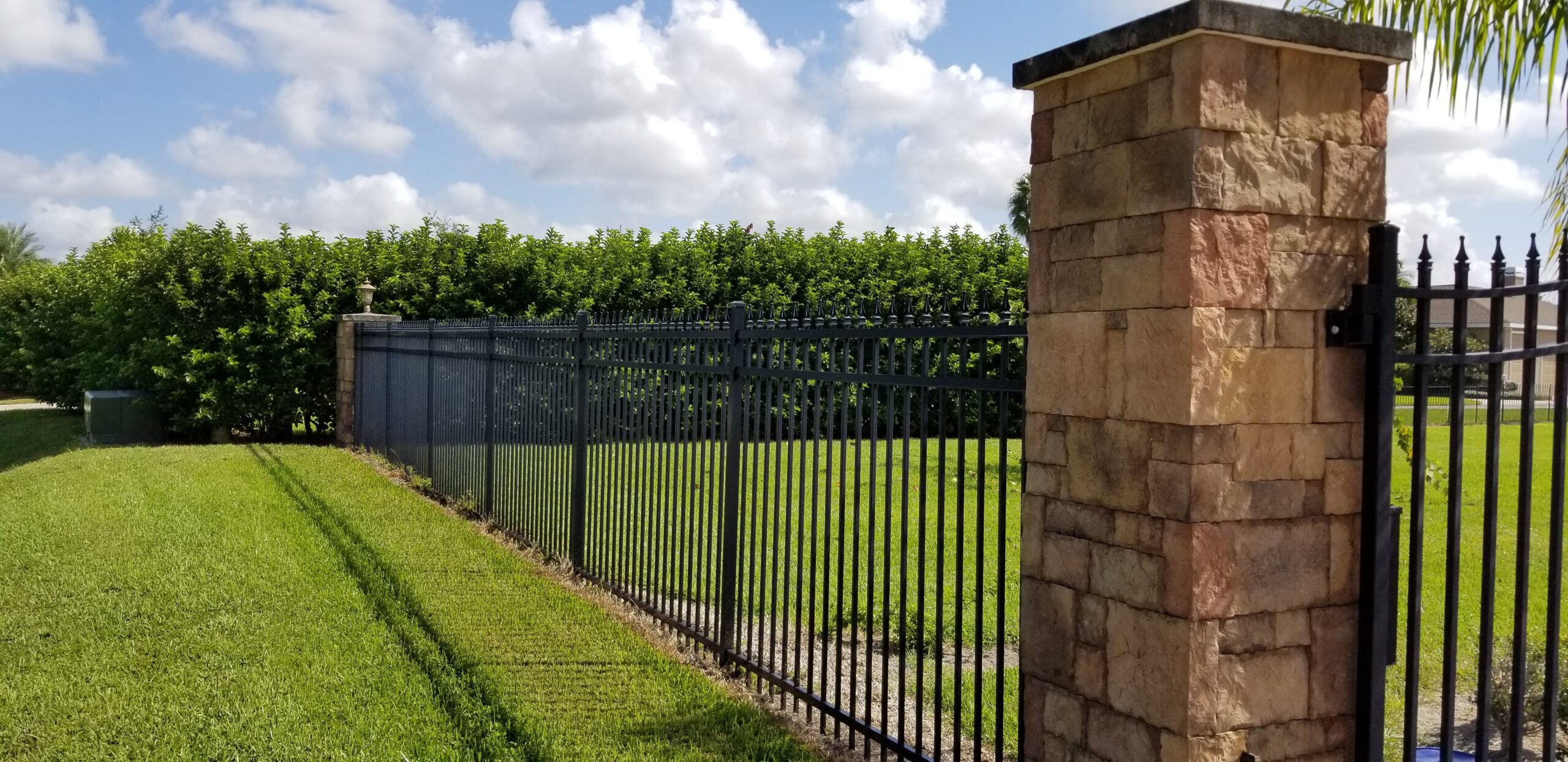 aluminum fence installation with brick pillars