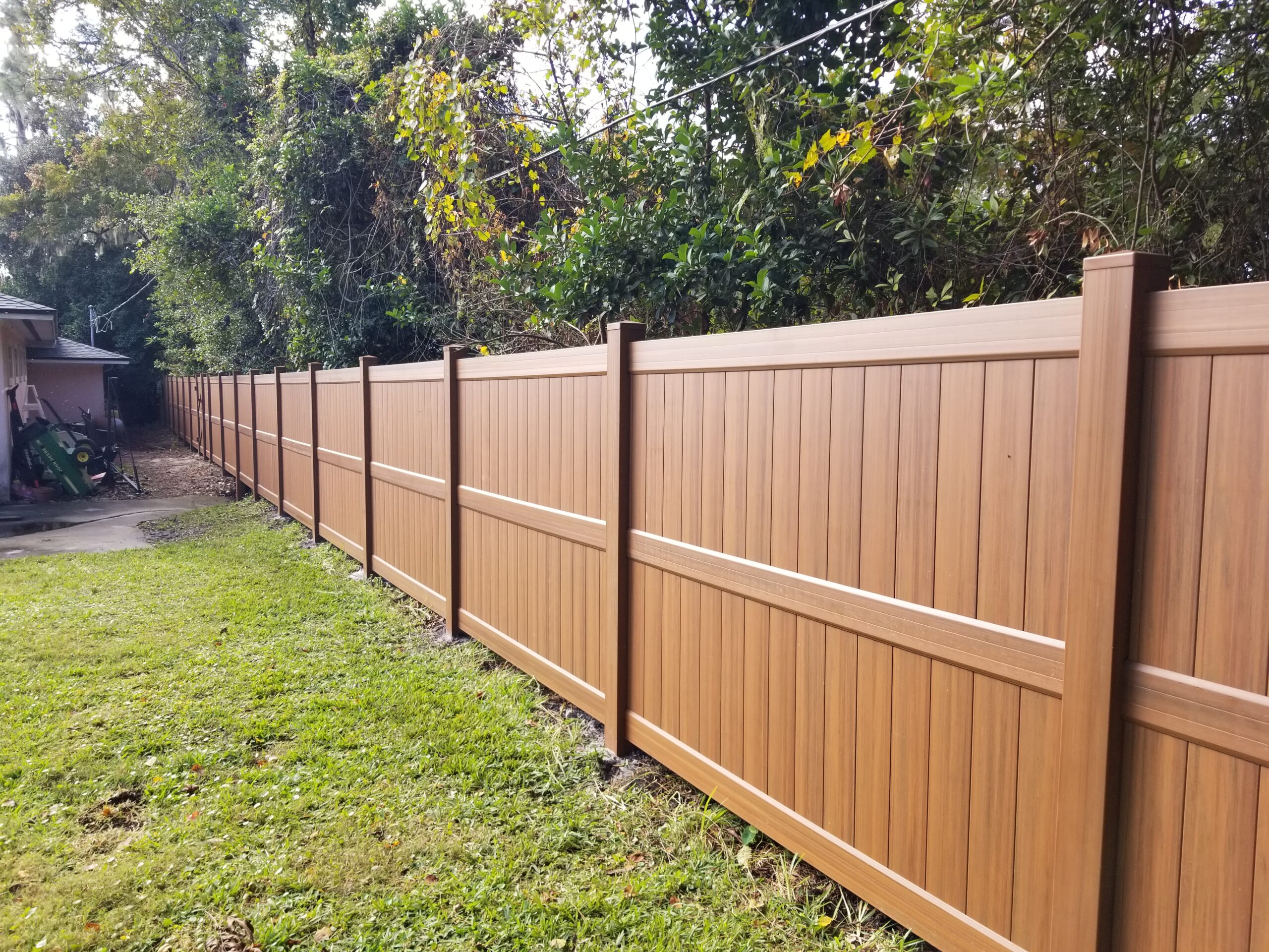 wood toned and textured vinyl fencing around a home in ocala florida
