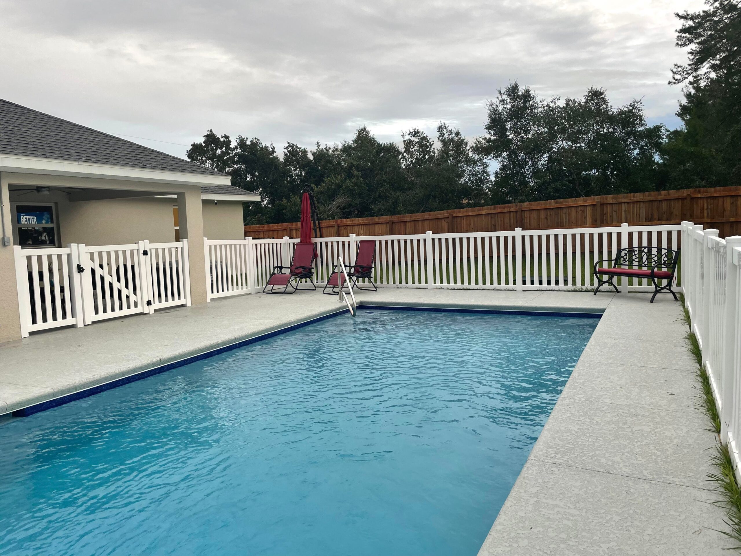 White vinyl fence installed around a residential swimming pool in Central Florida